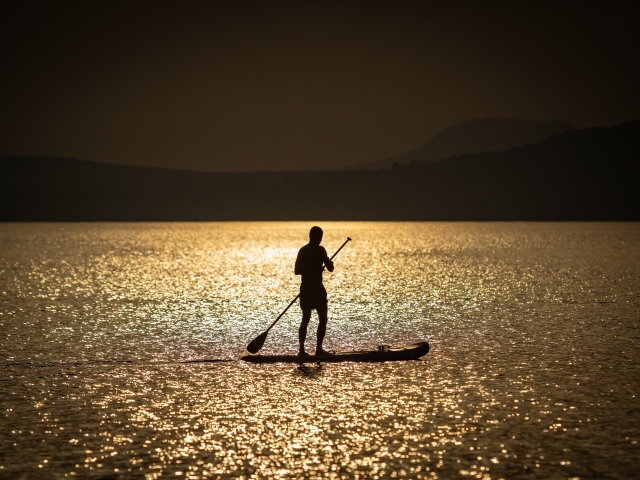Мужчина серфингист в море на закате