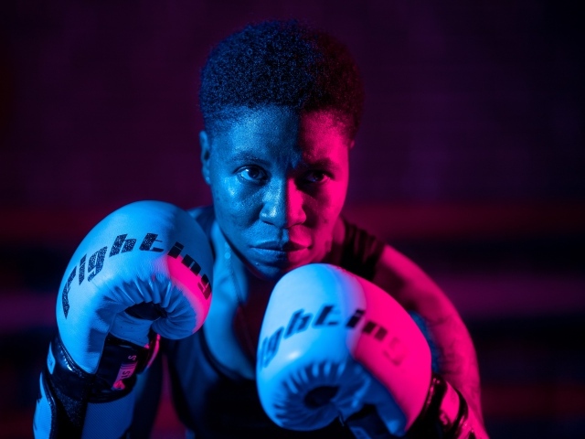 Мужчина в боксерских перчатках на черном фоне
