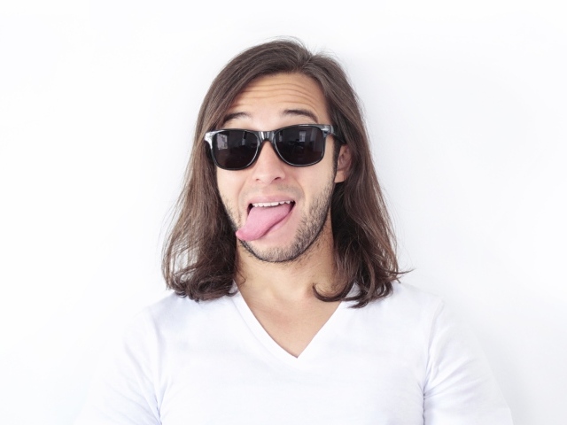 Мужчина в очках с высунутым языком