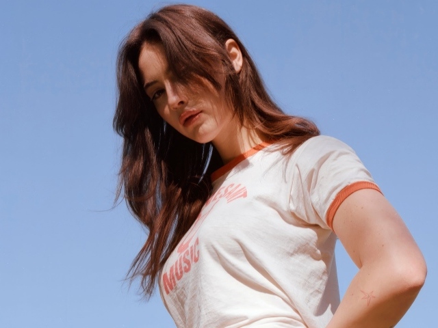 Американская певица Грэйси Абрамс на голубом фоне