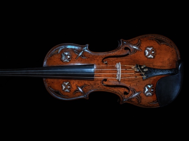 Большая деревянная скрипка на черном фоне
