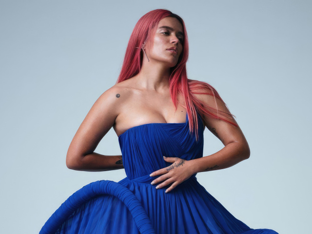 Певица Karol G в синем платье на сером фоне