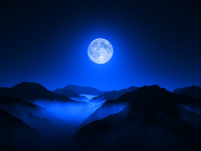 Большая луна в ночном небе над горами