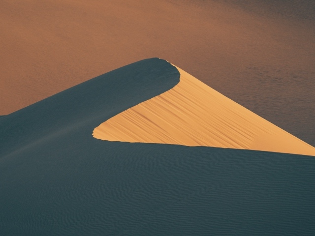Высокая песчаная дюна в лучах палящего солнца