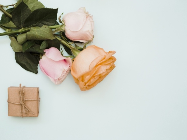 Три розы и подарок на сером фоне