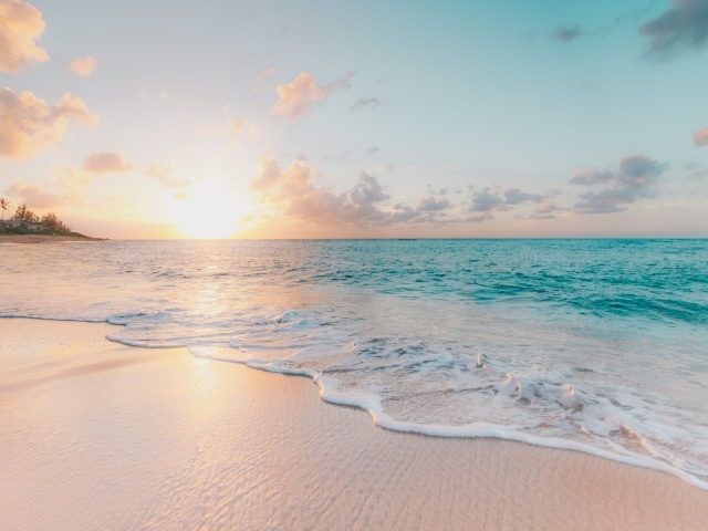 Красивая вода океана на песке в лучах закатного солнца