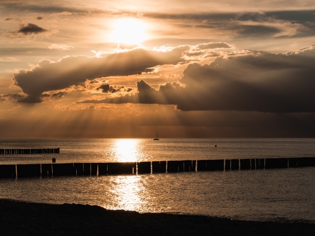 Яркое солнце за облаками над морем