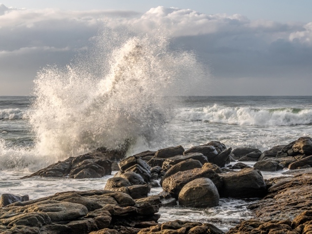 Морские волны бьются о камни на берегу