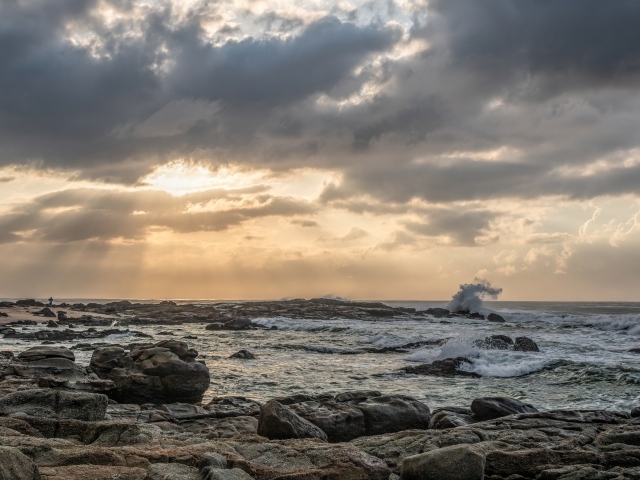 Лучи солнца пробиваются сквозь тучи над морем