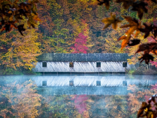 Дом отражается в озере осенью