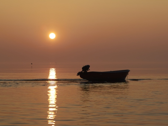 Лодка в море на закате солнца