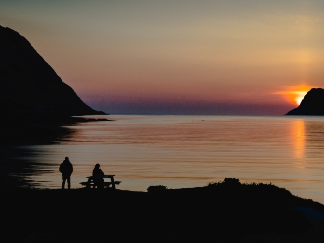 Солнце скрывается за горой в заливе