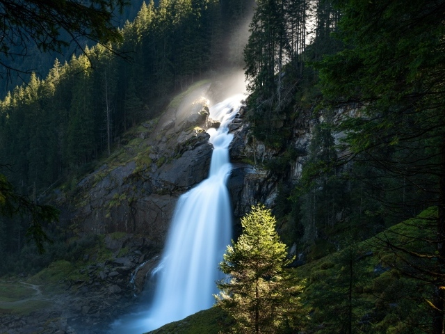 Водопад стекает по скале в лесу