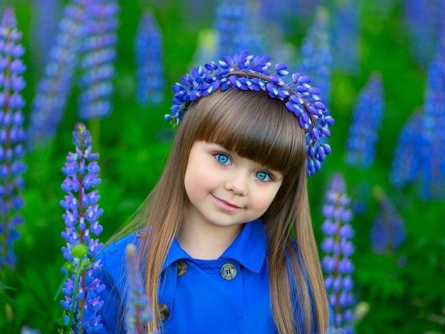 Красивая маленькая девочка в цветах люпина