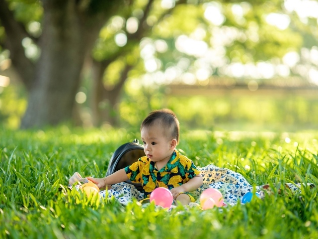 Милый маленький ребенок сидит на траве