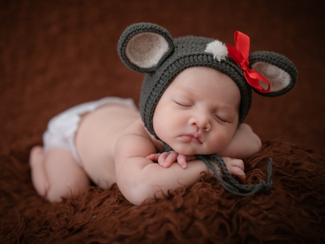 Смешная шапка на голове спящей малышки