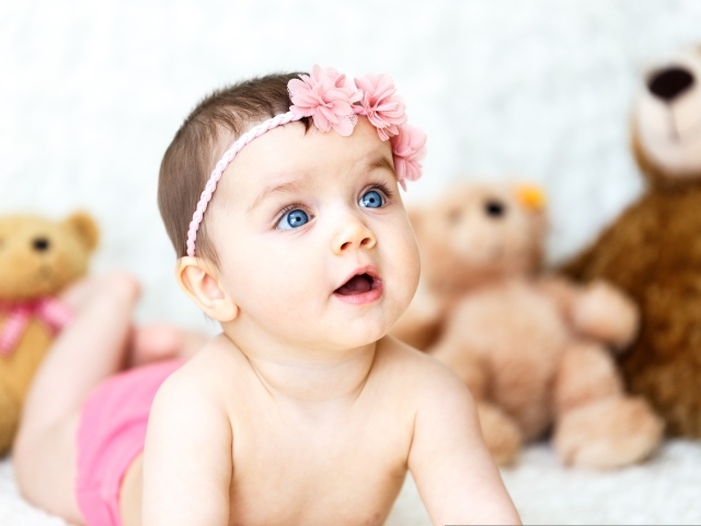 Девочка с голубыми глазами на фоне игрушек