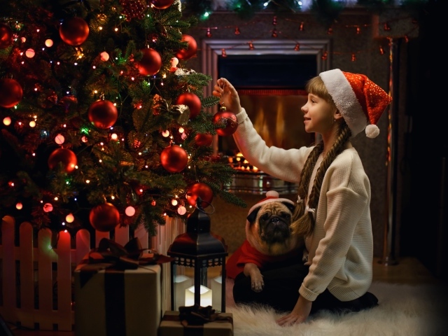 Маленькая девочка наряжает Рождественскую ель