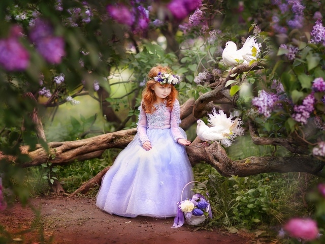 Маленькая девочка в красивом платье на дереве с голубями