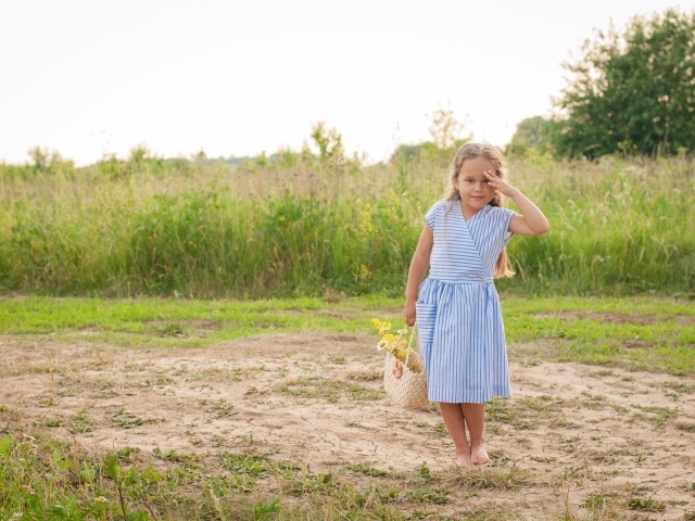 Маленькая девочка в платье с корзиной полевых цветов
