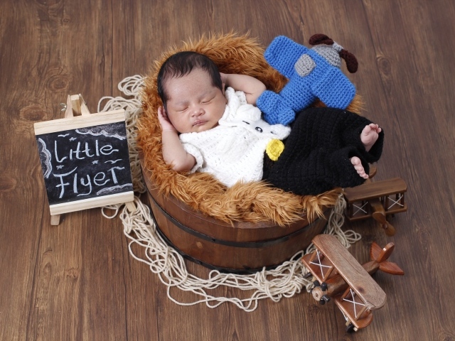 Маленький новорожденный малыш спит в бочке 