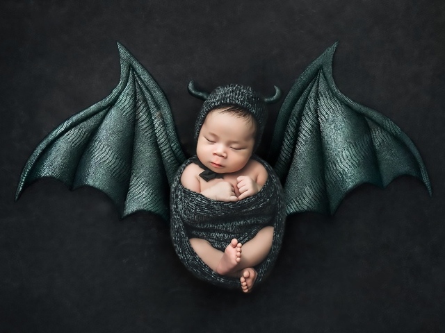 Маленький спящий ребенок с крыльями на Хэллоуин