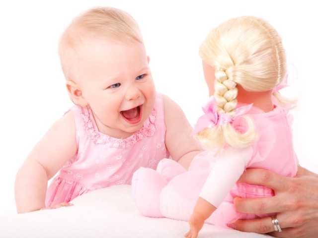 Маленькая улыбающаяся девочка с куклой