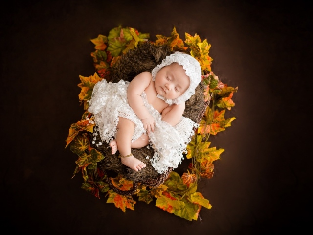 Новорожденная девочка в колыбели в белом костюме