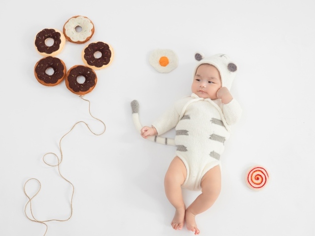 Новорожденный ребенок в костюме с пончиками