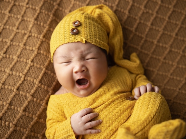 Новорожденный ребенок зевает во сне
