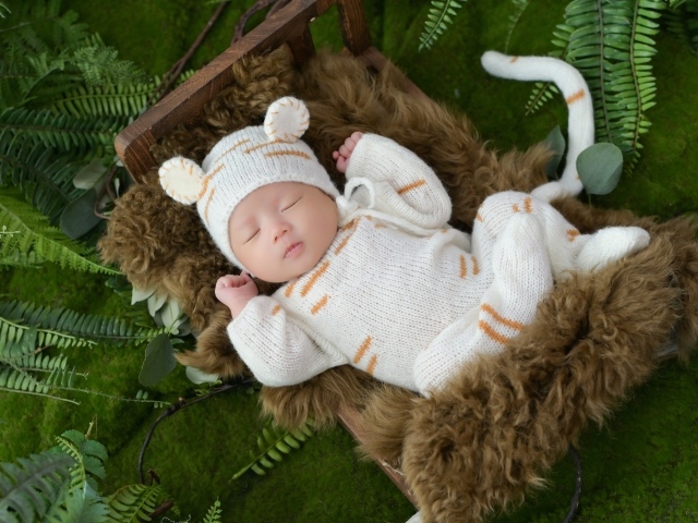 Спящий новорожденный ребенок в костюме тигренка