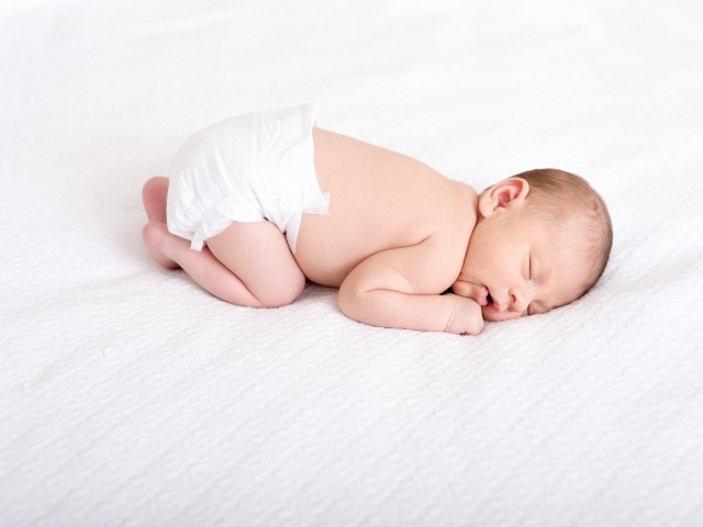 Спящий новорожденный ребенок в памперсе