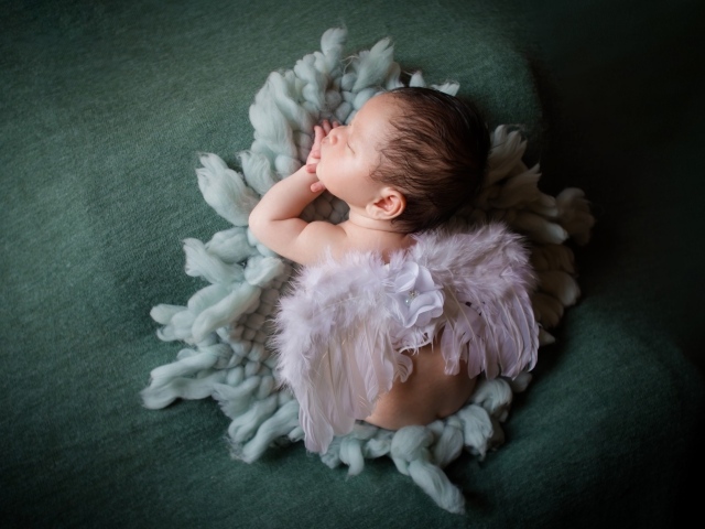 Спящий новорожденный малыш с крыльями ангела 
