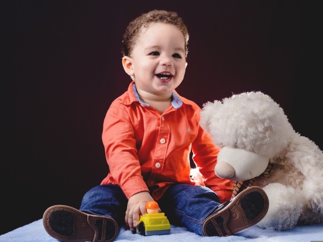 Улыбающийся мальчик с игрушечным медведем