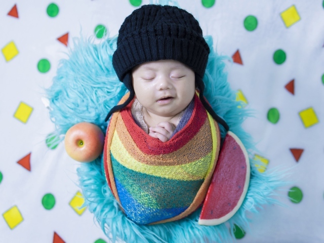 Улыбающийся ребенок в черной вязаной шапке 