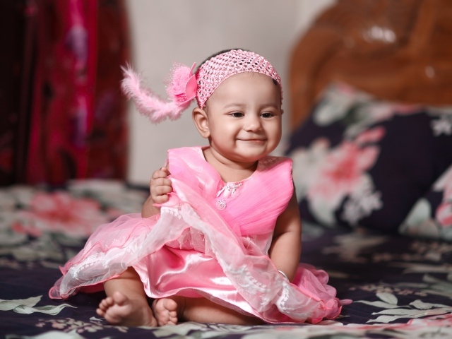 Улыбающаяся девочка в красивом розовом платье