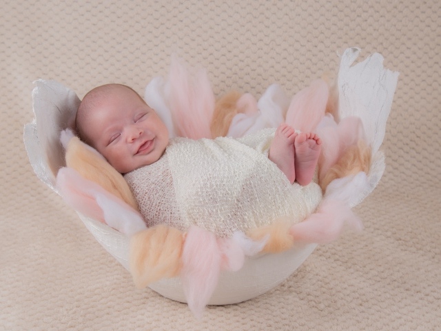 Улыбающийся спящий новорожденный малыш