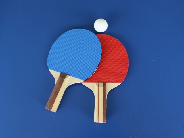 Две разноцветные ракетки и мяч для настольного тенниса