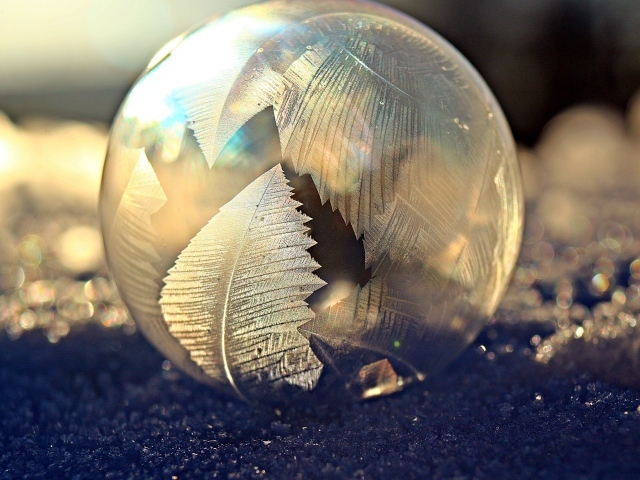 Морозный рисунок на мыльном пузыре на снегу зимой