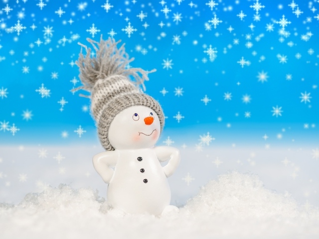 Игрушечный снеговик стоит на белом снегу