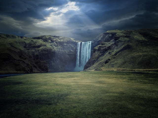 Лунный свет падает на горный водопад Скогафосс, Исландия