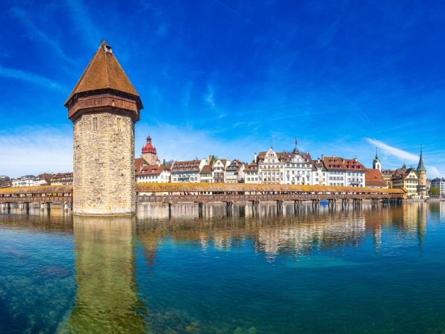Башня и дома отражаются в воде, город Люцерн. Швейцария