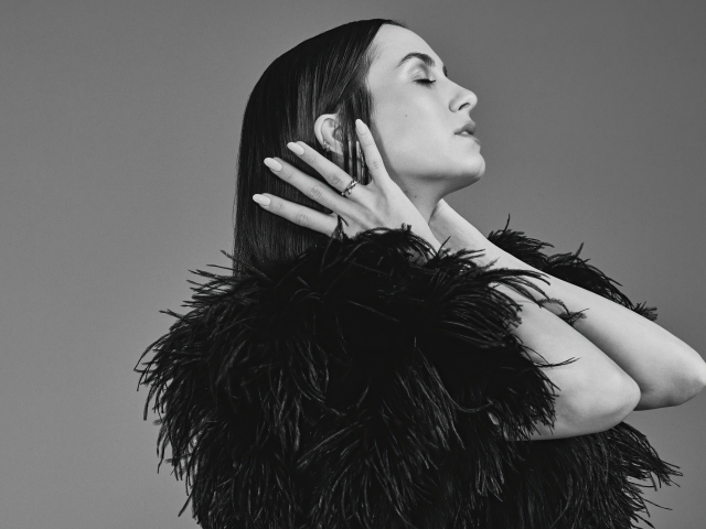 Актриса Мод Апатоу в черном платье на сером фоне