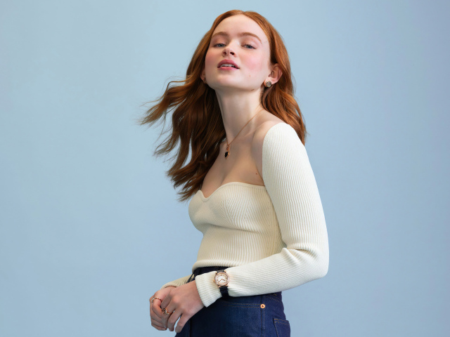 Актриса Сэди Синк в белом свитере на сером фоне