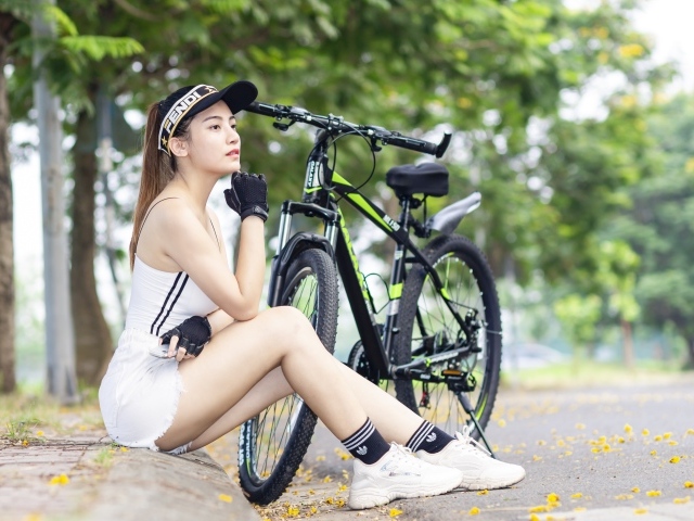 Спортивная девушка азиатка с велосипедом