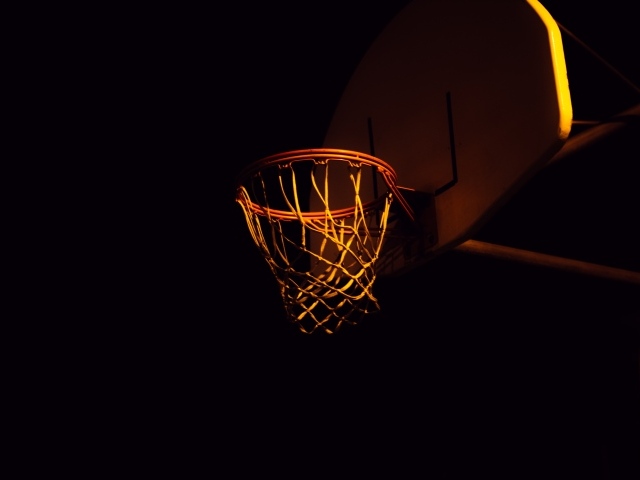 Баскетбольное кольцо в лучах света ночью