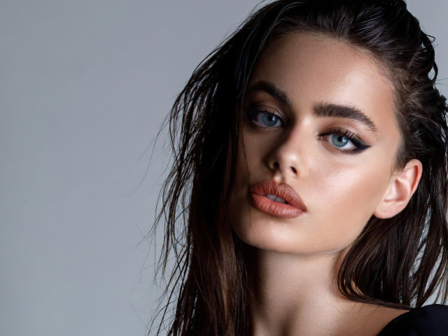 Красивая голубоглазая девушка Яэль Шелбиа на сером фоне