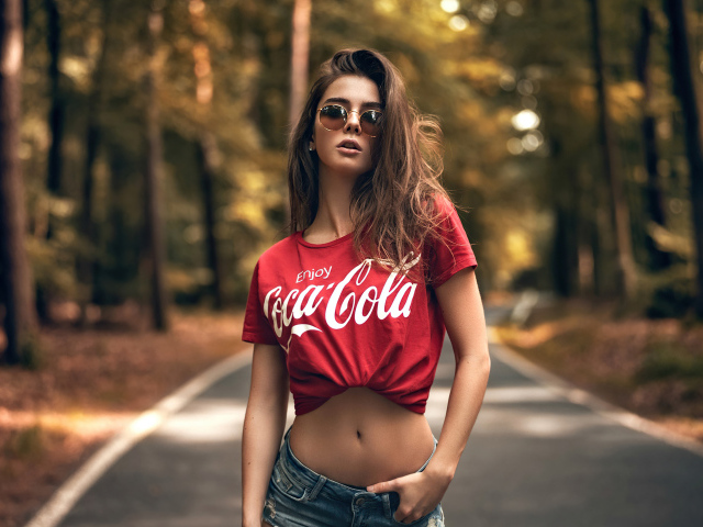 Красивая стройная девушка в футболке кока кола
