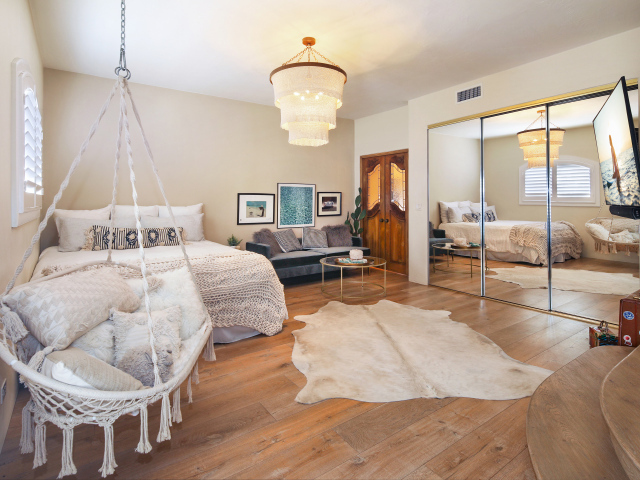 Спальня с белой кроватью и большим зеркалом