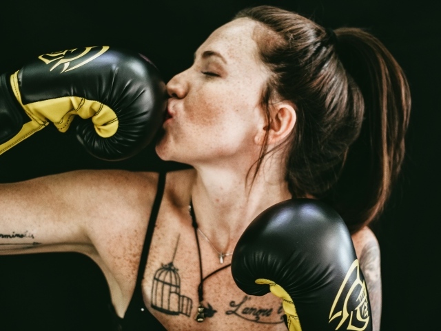 Девушка боксер целует перчатку